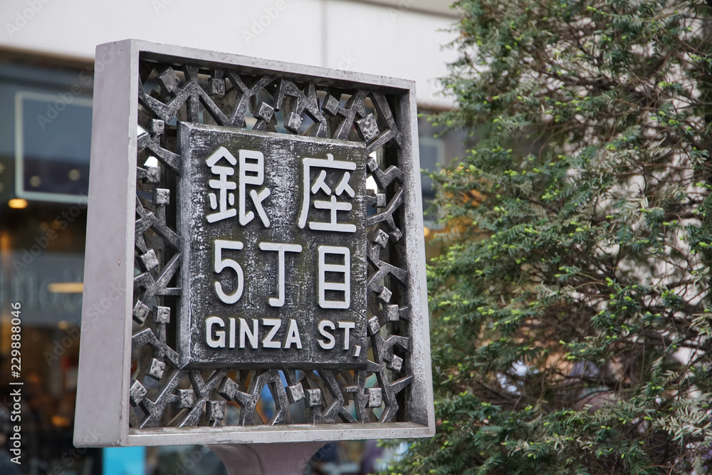 Fototapeta premium Tablica z nazwą miejsca przy ulicy Ginza 5 w wysokiej jakości centrum handlowym w Tokio w Japonii