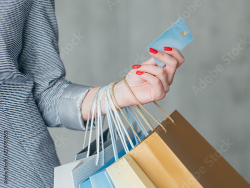 money loan for shopping. woman holding credit card and multiple bags in her hand.