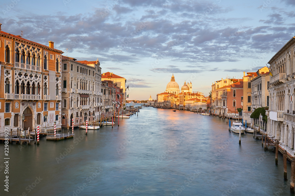 Grand Canal in Venice with Saint Mary of Health basilica, warm light at sunset in Italy
