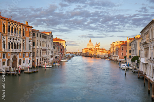 Grand Canal in Venice with Saint Mary of Health basilica, warm light at sunset in Italy