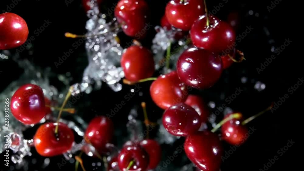 Cherry with water bouncing against to the camera on a black background in slow motion Cherry with water bouncing against to the camera on a black background in slow motion