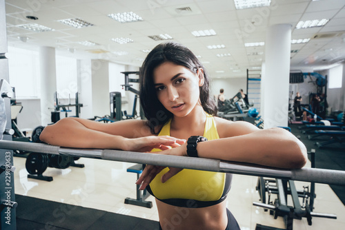 Beautiful athletic young woman making exercise at the gym. Young woman with muscular body.