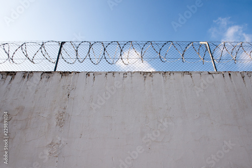  white wall with barb wire fence