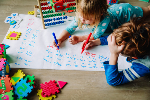 little boy and girl learn to write and calculate numbers