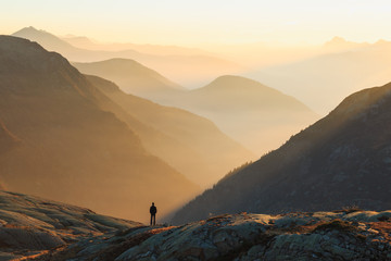 Fotobehang Beige Man looking at the coulorful layers of mountains during sunset. Chamonix, France.  © sanderstock