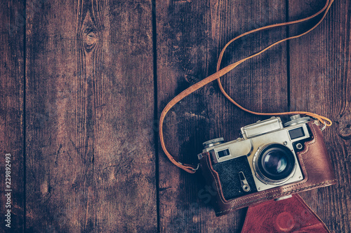 Old retro vintage camera on grunge wooden background