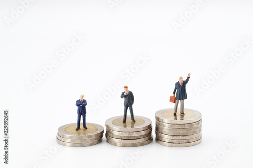 Miniature people: businessman standing on stacking coins , Financial and Business competition concept using as background.