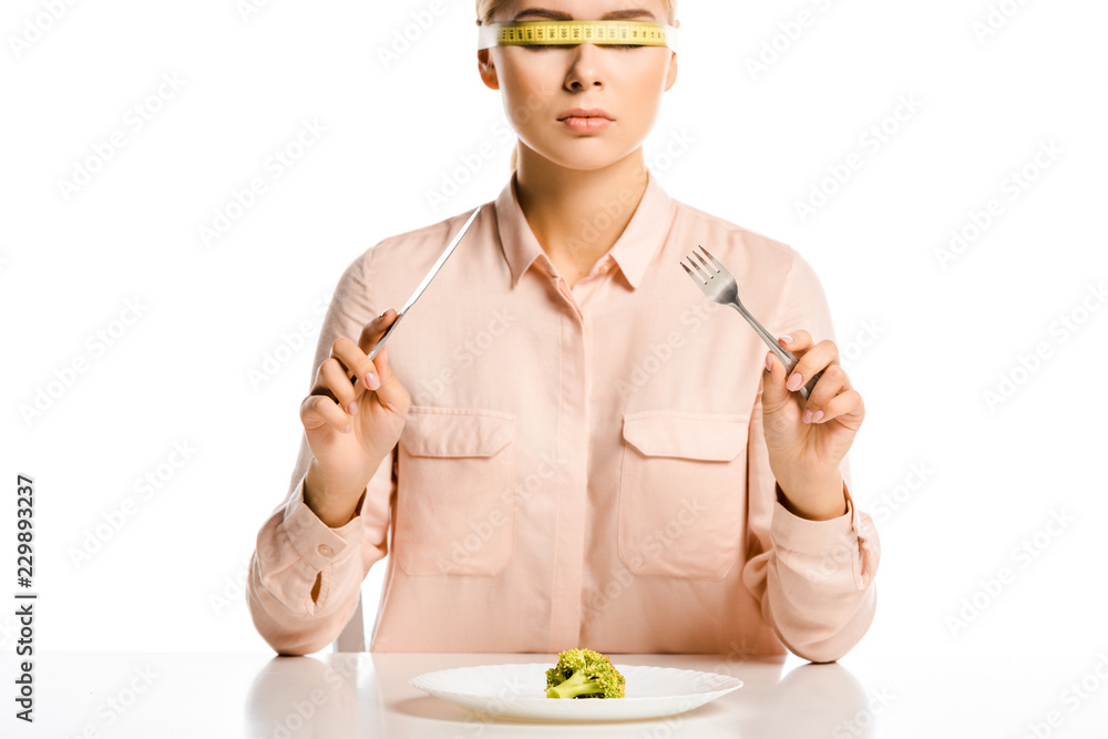 attractive woman with tape measure on eyes ready to eat broccoli isolated on white attractive woman with tape measure on eyes ready to eat broccoli isolated on white