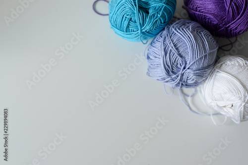 Creative decoration of colorful knitting wools for handmade on white table with copy space.
