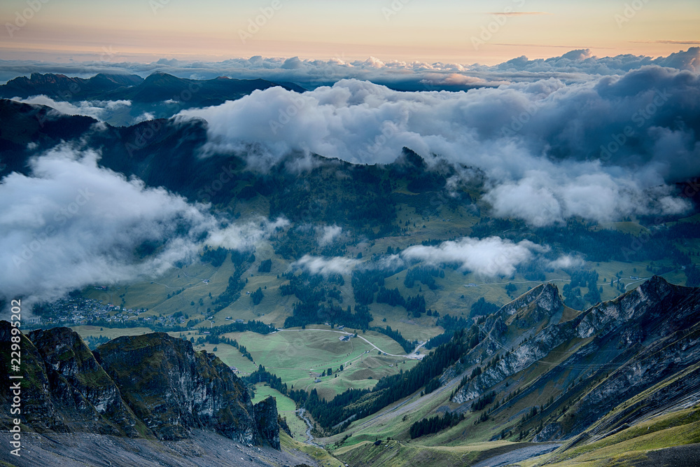 Scenic view on Teufimannsattel surrounded by few clouds and Emme valley Soerenberg from Brienzer Rothorn Swiss at sunrise