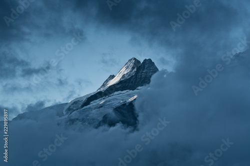 Summit Nässihorn at Grindelwald with glacier and snow in strong contrast framed by clouds