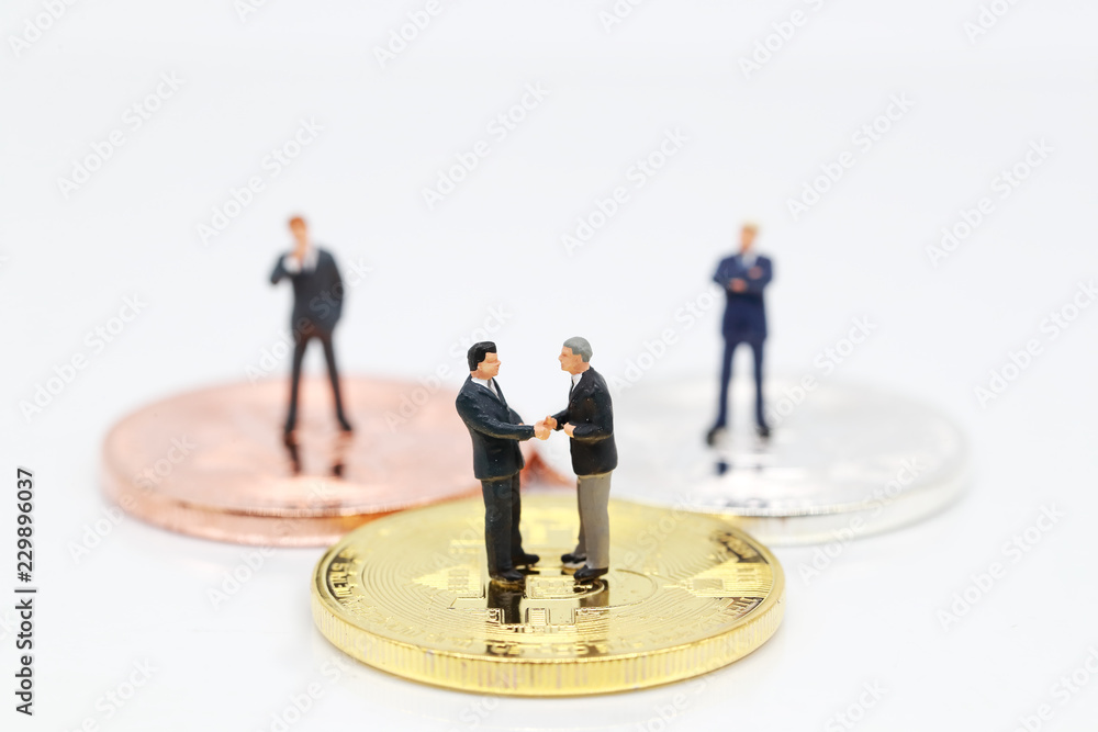 Miniature people: a group of businessman standing on bitcoin (this image for financial and business competition concept) Miniature people: a group of businessman standing on bitcoin (this image for financial and business competition concept)