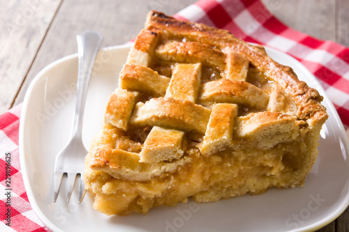 Homemade apple pie slice on wooden table
