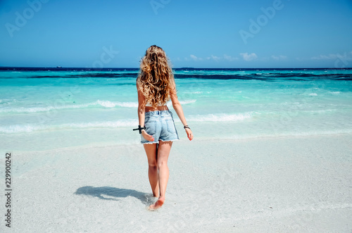 Young blonde woman on paradise beach blue ocean sea view