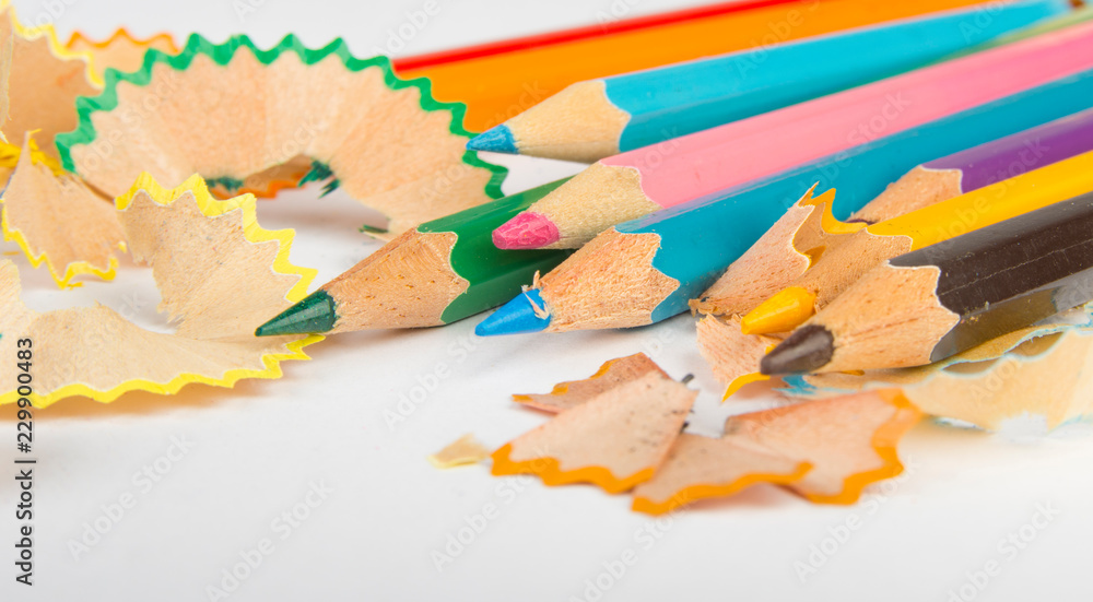 Colored pencils and shavings on white background. Colored pencils and shavings on white background.