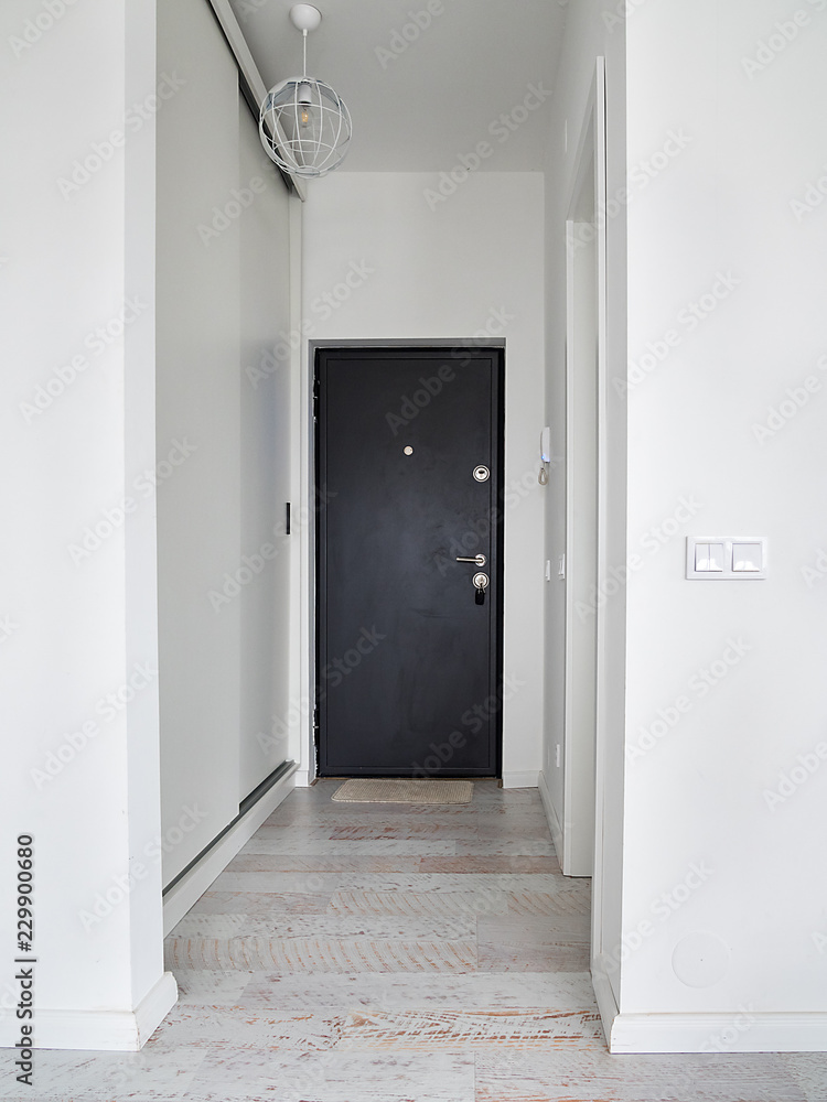 Empty hallway with closed door inside an apartment. White corridor inside an apartment block. Empty hallway with closed door inside an apartment. White corridor inside an apartment block.