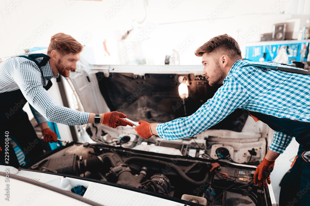 Two Auto Mechanics Are Looking Under The Hood. Two Auto Mechanics Are Looking Under The Hood.