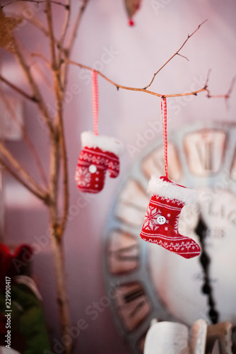 Decorated Christmas tree closeup. Red socks or boots and illuminated garland with flashlights. New Year baubles macro photo with bokeh. Winter holiday light decoration