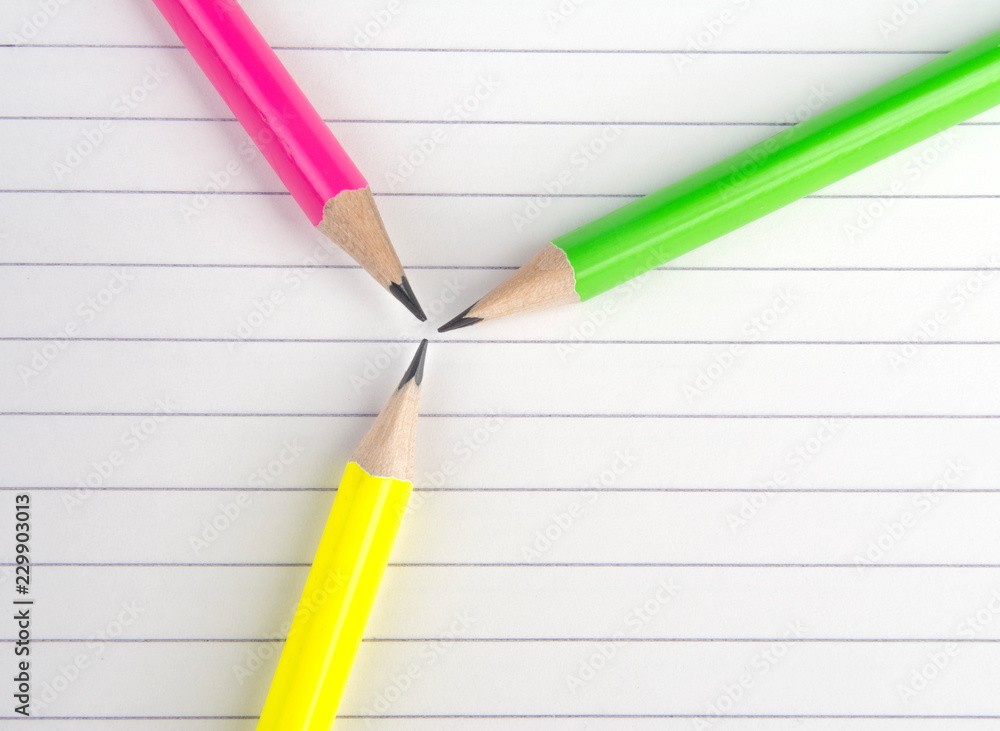 Colored pencils are on the notebook. Colored pencils are on the notebook.
