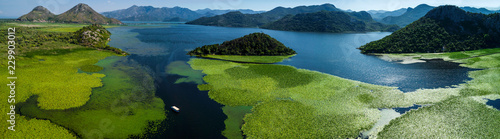 Aerial panoramic view of the beautiful landscape of Lake Skadar in the mountain on a sunny day. Montenegro. The territory of Lake Skadar overgrown with plants.