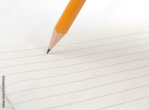 Stylus pencil closeup writes on the notebook.