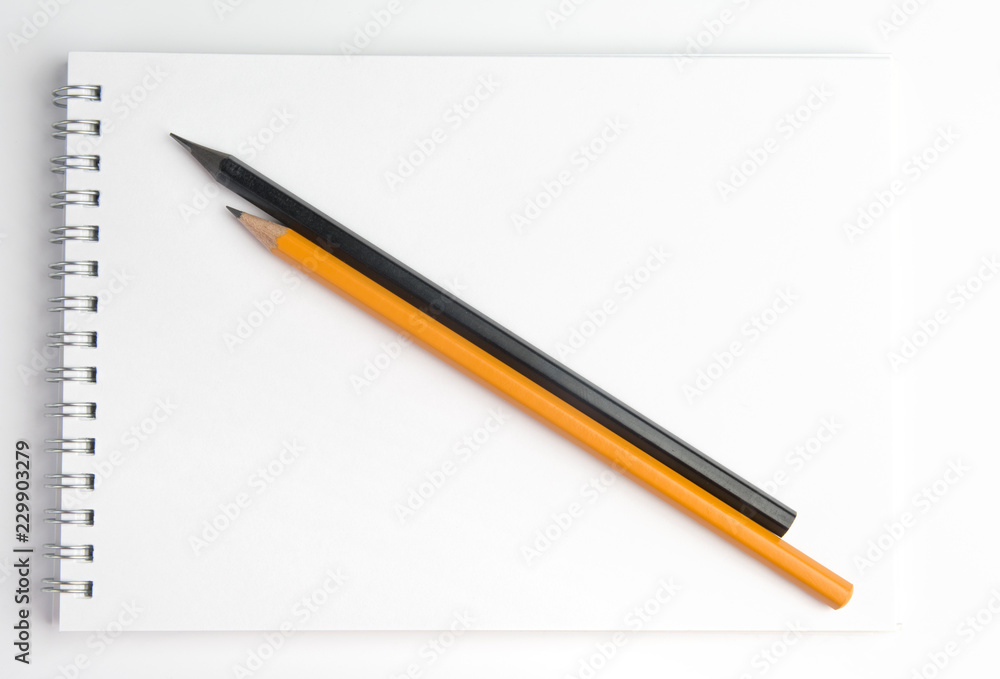 The pencil lying on the notebook. Close up. The pencil lying on the notebook. Close up.