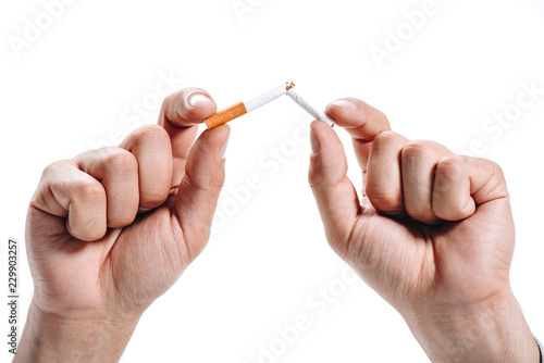 cropped image of man breaking unhealthy cigarette isolated on white