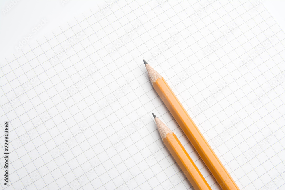 The pencil lying on the notebook. Close up. The pencil lying on the notebook. Close up.