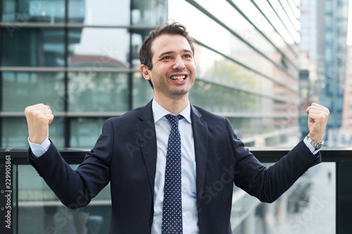 Businessman celebrating rising his arms after good news
