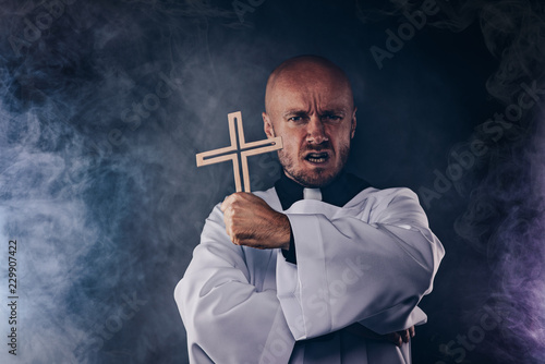 Tableau sur toile Catholic priest exorcist in white surplice and black shirt