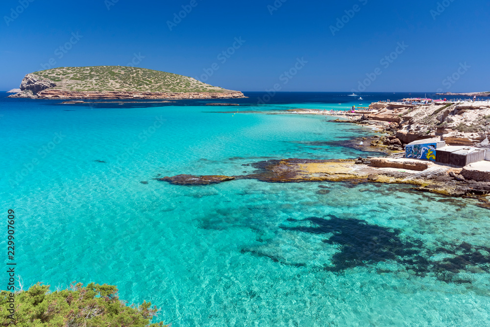 Fototapeta premium Ibiza - Cala Comte, Blick auf die Cala Escondida und über das Meer zur Cala Comte mit der Insel Illa des Bosc