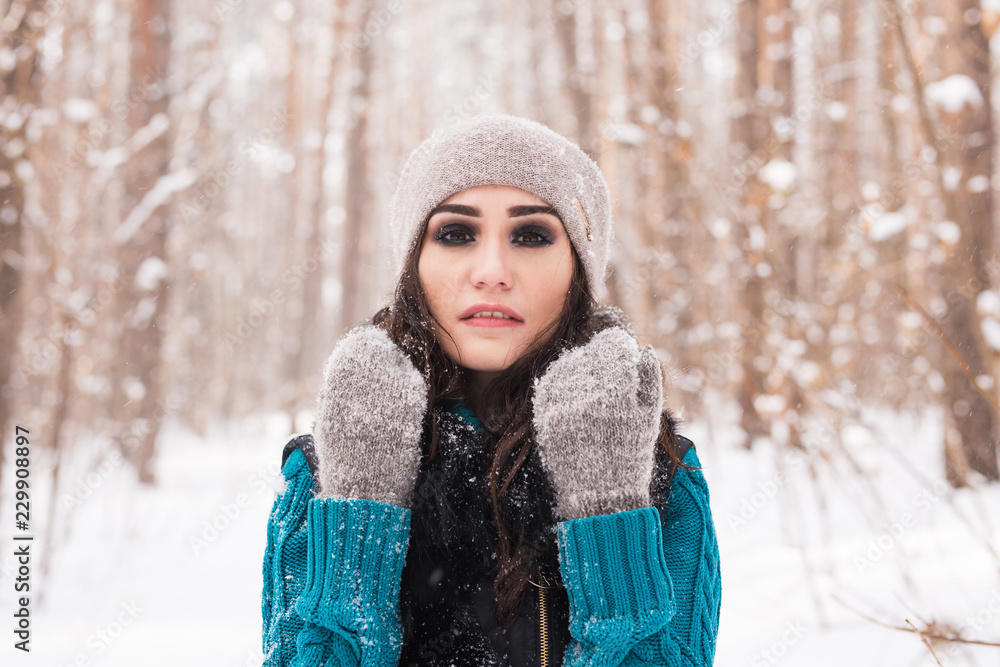 Winter, season and people concept - Portrait of young pretty woman walking in snowy park Winter, season and people concept - Portrait of young pretty woman walking in snowy park