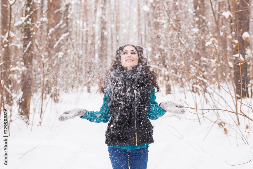 Young pretty woman throwing snow in the air in winter holidays Young pretty woman throwing snow in the air in winter holidays