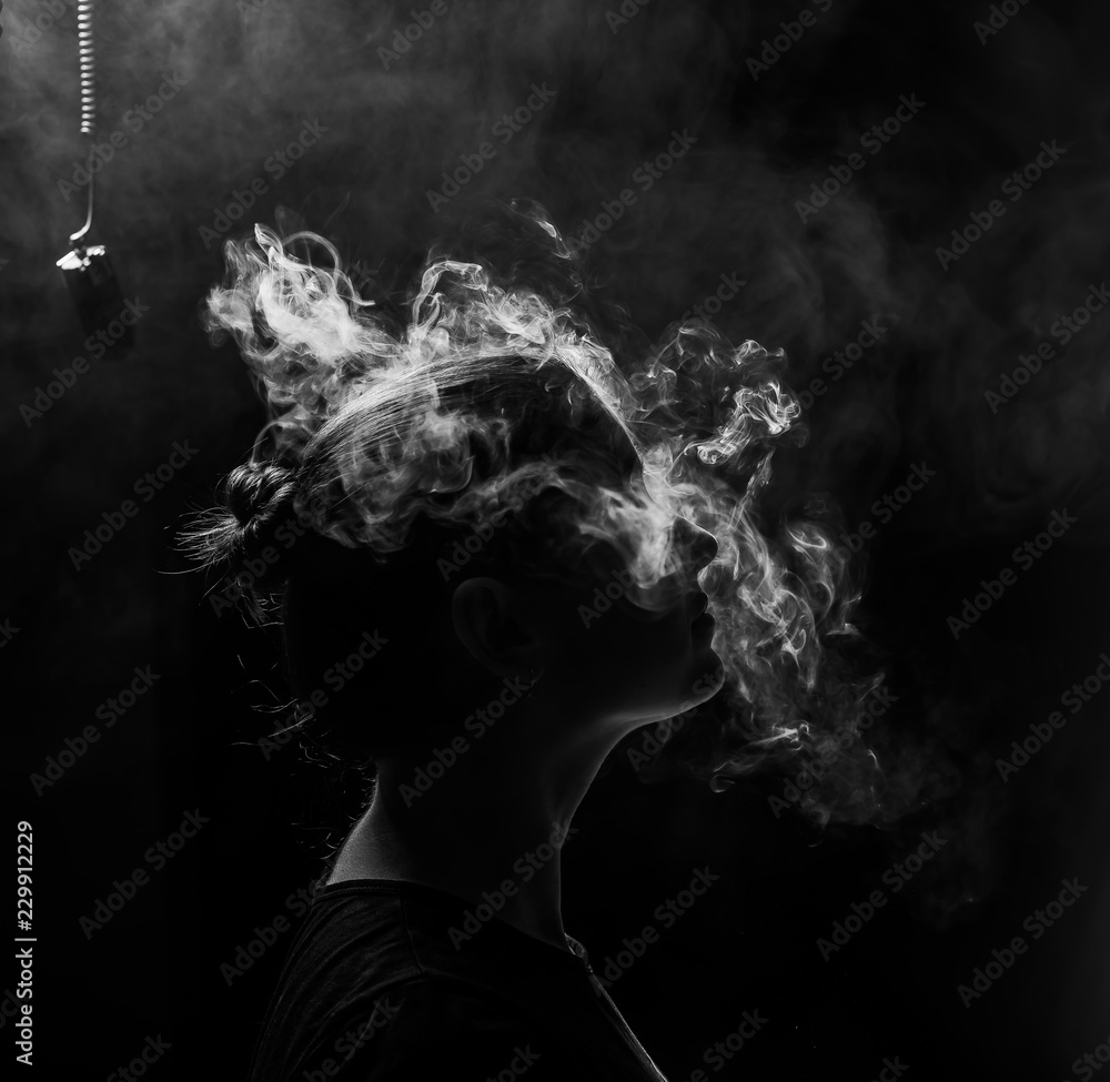 profile of a beautiful girl on a black background. The face of a girl  exhaling smoke. Smoking redhead woman. Head in hookah smoke Stock Photo |  Adobe Stock