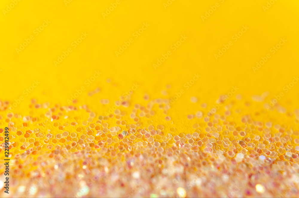 Glitter and bokeh lights on a bright yellow background, magical diamond effect, shallow depth, christmas, new year, carnival, night party invitation or festive background, copy space for text Glitter and bokeh lights on a bright yellow background, magical diamond effect, shallow depth, christmas, new year, carnival, night party invitation or festive background, copy space for text