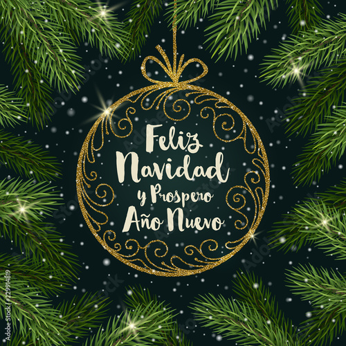 Feliz navidad - Christmas greetings in Spanish. Glitter gold ornate bauble with brush calligraphy Christmas greeting  surrounded by Christmas tree branches.