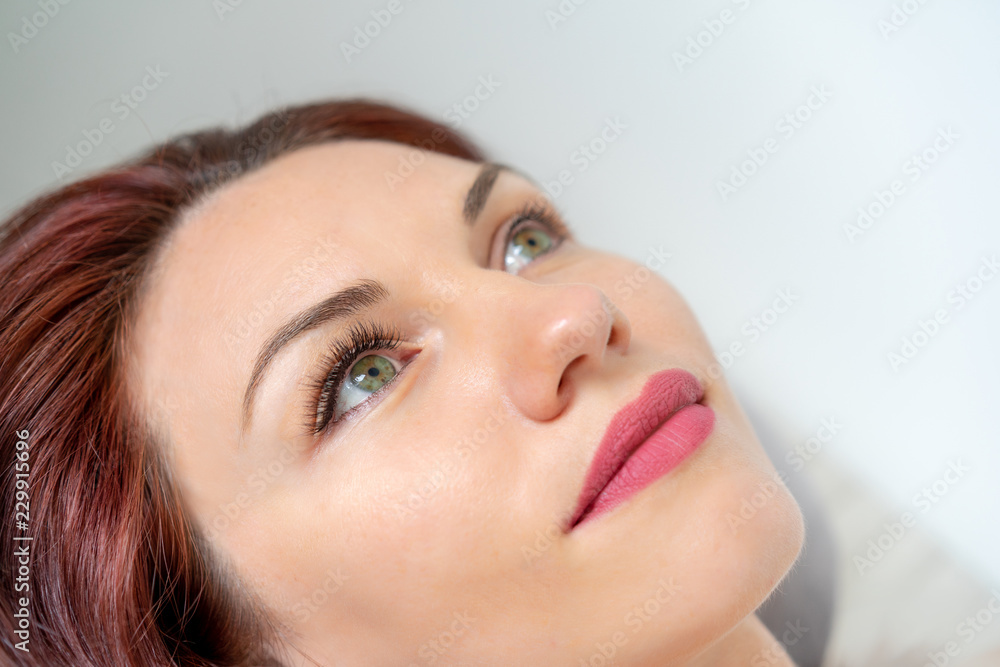 Beautiful woman with long eyelashes in a beauty salon. Eyelash extension procedure. Lashes close up Beautiful woman with long eyelashes in a beauty salon. Eyelash extension procedure. Lashes close up