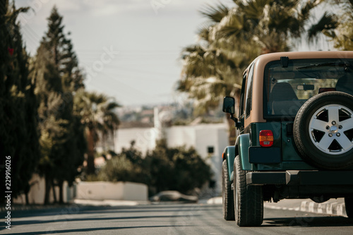 Suv car is parked at the city street. Pickup car drive along resort town street