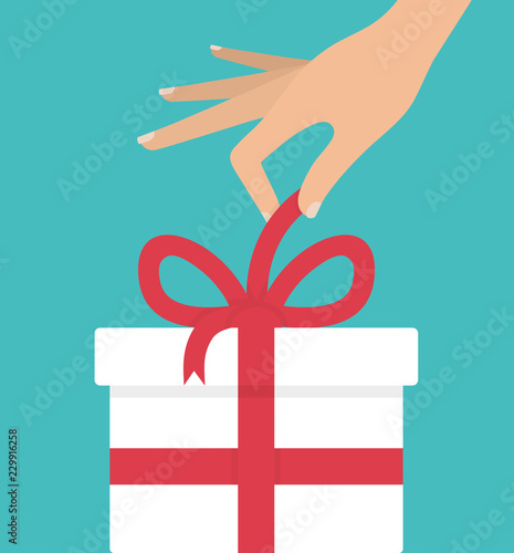 Woman's hand unpacking or unwrapping white gift box with red bow