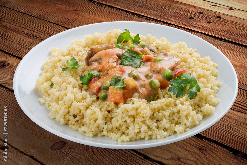 Millet porridge with mushrooms. On a wooden background Millet porridge with mushrooms. On a wooden background