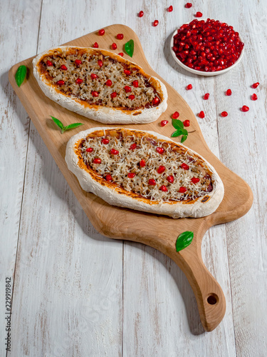 Traditional Arabic pizza manaqish with meat and pomegranate.
