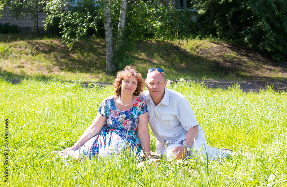 Fototapeta premium man and woman sit on the grass