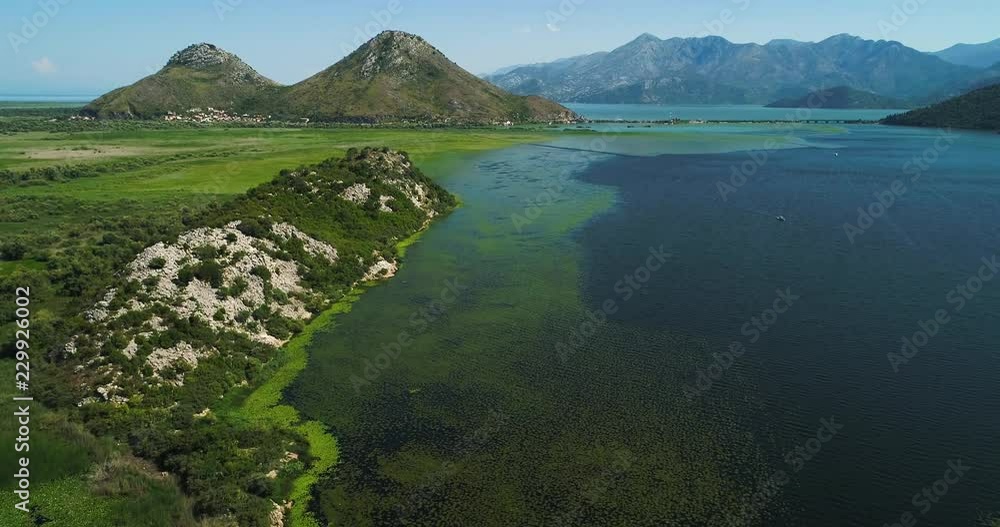 Aerial view of the beautiful landscape of Lake Skadar in the mountain on a sunny day. Montenegro. The territory of Lake Skadar overgrown with plants. Aerial view of the beautiful landscape of Lake Skadar in the mountain on a sunny day. Montenegro. The territory of Lake Skadar overgrown with plants.