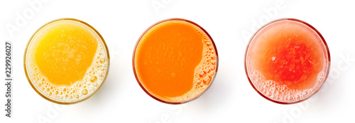 Fototapeta Fresh orange carrot and grapefruit juices isolated on white, from above