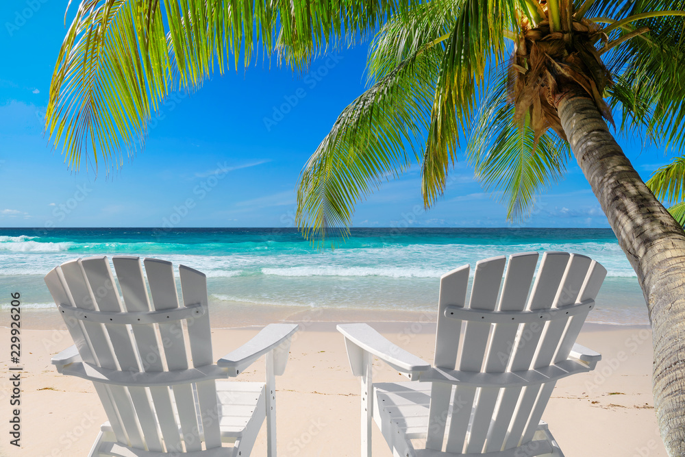 Beach chairs for vacation on beautiful sandy beach and turquoise sea on paradise island. Summer vacation and tropical beach concept.  