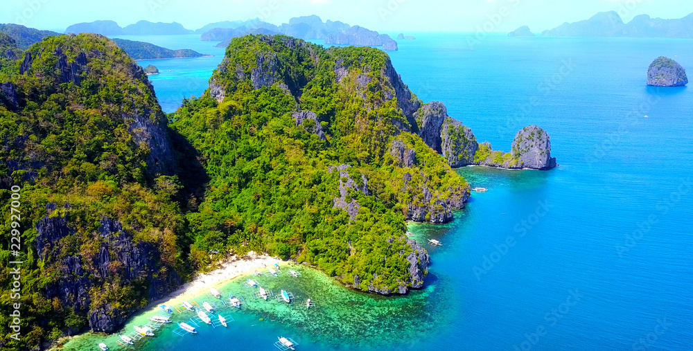 Exotic Beach Cove With Catamaran Style Boats On Rocky Tropical Island - El Nido, Palawan, Philippines - Aerial View - obrazy, fototapety, plakaty 