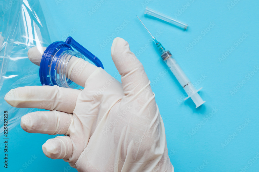hand in medical glove holding empty plastic bottle, laboratory plastic check, shelf life, analysis hand in medical glove holding empty plastic bottle, laboratory plastic check, shelf life, analysis