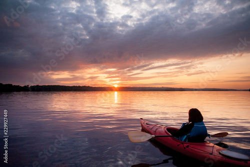 Woman in a kayak on the river on the scenic sunset © MIRACLE MOMENTS