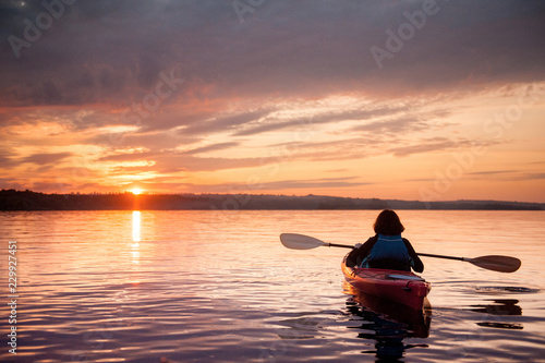Woman in a kayak on the river on the scenic sunset © MIRACLE MOMENTS