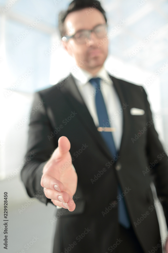 businessman holding out his hand for a handshake businessman holding out his hand for a handshake